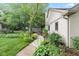 Side yard showcasing a manicured garden with blooming flowers and a charming walkway at 1482 Waterford Dr, Zionsville, IN 46077