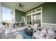 Relaxing covered outdoor patio complete with ceiling fan, comfortable seating, dining table, and a view of the yard at 15926 Bellows Ave, Fishers, IN 46040
