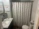 Cozy bathroom featuring a marble countertop vanity and a shower/tub combo with a floral shower curtain at 162 W Robertson Rd, Morgantown, IN 46160