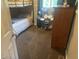 A view of a bedroom featuring a bunk bed, a dresser, an electronic drum set, and carpet flooring at 162 W Robertson Rd, Morgantown, IN 46160