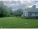 Ranch home featuring stone accents, a covered porch, and a large yard with mature trees, offering a peaceful retreat at 162 W Robertson Rd, Morgantown, IN 46160
