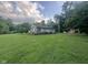 Ranch home featuring stone accents, a covered porch, and a large yard with mature trees, offering a peaceful retreat at 162 W Robertson Rd, Morgantown, IN 46160