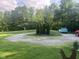 Beautiful front yard with a circular gravel driveway, mature trees, and a manicured lawn, enhancing curb appeal at 162 W Robertson Rd, Morgantown, IN 46160