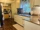 A view of a kitchen featuring a sink, window, white cabinets, and appliances at 162 W Robertson Rd, Morgantown, IN 46160