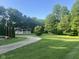 Scenic view of a home with a winding gravel driveway and expansive green yard surrounded by mature trees at 162 W Robertson Rd, Morgantown, IN 46160