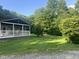 Lush green lawn surrounds this cozy home with a charming covered porch and wooded backdrop at 162 W Robertson Rd, Morgantown, IN 46160