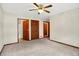 Bright bedroom with neutral walls and carpet, ceiling fan, with ensuite bathroom and closet doors at 177 Jacinta Pl, Bargersville, IN 46106