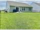 Lush backyard featuring green grass, patio, grill, and black fence, perfect for outdoor living at 213 Drewood Dr, Trafalgar, IN 46181