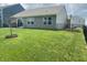 Well-maintained backyard with lush green grass, a black fence, and a charming tree at 213 Drewood Dr, Trafalgar, IN 46181