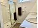 Well-lit bathroom with a dual sink vanity, framed mirror, and a modern glass door shower at 213 Drewood Dr, Trafalgar, IN 46181