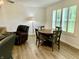 Open floor plan dining area with hardwood floors and bright natural light from the window at 213 Drewood Dr, Trafalgar, IN 46181