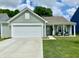 Charming single story home features a two-car garage, covered porch with chairs, and a well-manicured lawn at 213 Drewood Dr, Trafalgar, IN 46181