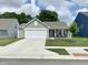 Charming home exterior featuring a well-manicured lawn, two-car garage, and inviting front porch at 213 Drewood Dr, Trafalgar, IN 46181