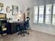Home office features a dark wooden desk, swivel chair, neutral carpeting, and natural light from a bright window at 213 Drewood Dr, Trafalgar, IN 46181