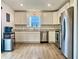 Modern kitchen features stainless steel appliances, white cabinetry, and a view from the window over the sink at 213 Drewood Dr, Trafalgar, IN 46181