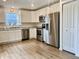 Bright kitchen with white cabinets, stainless steel appliances, and laminate flooring at 213 Drewood Dr, Trafalgar, IN 46181