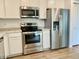 Updated kitchen features stainless steel appliances, white cabinetry and laminate flooring at 213 Drewood Dr, Trafalgar, IN 46181