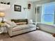Cozy sitting room with a plush sofa, side table, and natural light from the window at 213 Drewood Dr, Trafalgar, IN 46181