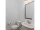 Simple half bathroom with a toilet, sink, mirror, and wall-mounted towel at 2169 Aviary Ln, Danville, IN 46122