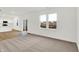 Spacious living room with modern lighting, neutral carpet, and sliding glass doors to the outside at 2227 Foothill Dr, Greenfield, IN 46140