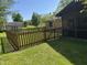View of a well-maintained backyard with a wooden fence, lush lawn, and mature trees at 2937 S Allen Dr, New Palestine, IN 46163