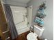 Bathroom with combination tub and shower, white subway tile surround, and decorative gray towels at 2937 S Allen Dr, New Palestine, IN 46163