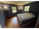 Bedroom with hardwood floors, warm lighting, and blue walls, providing a calm and inviting space at 2937 S Allen Dr, New Palestine, IN 46163