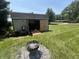 The shed is surrounded by green grass and a fire pit at 2937 S Allen Dr, New Palestine, IN 46163