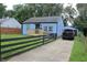 Exterior of the home featuring a driveway, manicured lawn, and a matching detached garage in the back at 3201 W 22Nd St, Indianapolis, IN 46222