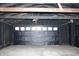 Garage features a black overhead door, paneled walls and concrete flooring at 3201 W 22Nd St, Indianapolis, IN 46222