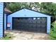 Exterior view of the home's garage with a black door and for sale sign at 3201 W 22Nd St, Indianapolis, IN 46222