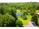 An aerial view of home surrounded by tall, mature trees and a large pond at 3265 Tulip Dr, Indianapolis, IN 46227