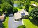 A beautiful aerial view of a home with mature trees, green lawn, pond, outbuilding and solar panels at 3265 Tulip Dr, Indianapolis, IN 46227