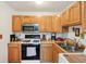 Functional kitchen features wood cabinets, modern appliances, and gas range at 3265 Tulip Dr, Indianapolis, IN 46227