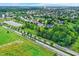 High-angle view captures a suburban area with houses scattered among green lawns, trees, and sports fields at 3345 Kilkenny Cir, Carmel, IN 46032