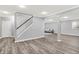 Finished basement with light gray walls, wood floors, staircase and gray sofa at 3345 Kilkenny Cir, Carmel, IN 46032