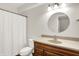 Bathroom featuring wood vanity, round mirror, toilet, and shower with white curtain at 3345 Kilkenny Cir, Carmel, IN 46032