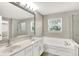 Bathroom featuring double sink vanity, soaking tub with tile surround and glass-enclosed shower at 3345 Kilkenny Cir, Carmel, IN 46032