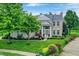 Charming two-story home with well-manicured lawn, garden beds, and a welcoming entrance at 3345 Kilkenny Cir, Carmel, IN 46032