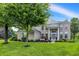 Charming brick home features a well-manicured lawn, mature tree, and inviting front porch with white columns at 3345 Kilkenny Cir, Carmel, IN 46032