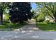 Charming home with an attached garage and a well-maintained lawn, shaded by mature trees along the driveway at 3440 W 46Th St, Indianapolis, IN 46228