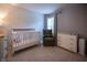 Neutral toned Bedroom with a crib, rocking chair, changing table, and leaf pattern wallpaper at 3474 Glen Abbe Ct, Carmel, IN 46032