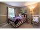 Well-lit bedroom featuring a queen-size bed, neutral carpet and walls, and a small side table at 3474 Glen Abbe Ct, Carmel, IN 46032
