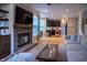 Open concept living room with a fireplace, hardwood floors, and view into a modern kitchen at 3474 Glen Abbe Ct, Carmel, IN 46032