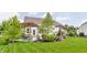 Backyard view showcasing a charming patio with a pergola, swing, fire pit, and lush landscaping at 3606 Evergreen Way, Zionsville, IN 46077