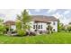 Backyard view showcasing a charming patio with a pergola, swing, fire pit, and lush landscaping at 3606 Evergreen Way, Zionsville, IN 46077