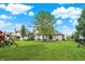 The backyard showcases a sprawling lawn with a playset and patio dining at 3740 Weather Stone Xing, Zionsville, IN 46077