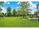 Large backyard with lush green grass, playset, and a patio set at 3740 Weather Stone Xing, Zionsville, IN 46077