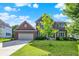 Lovely brick home with an attached garage and well-maintained lawn on a sunny day at 3740 Weather Stone Xing, Zionsville, IN 46077