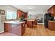 Kitchen showcases an island, wooden cabinetry, tiled backsplash, and hardwood floors at 3740 Weather Stone Xing, Zionsville, IN 46077